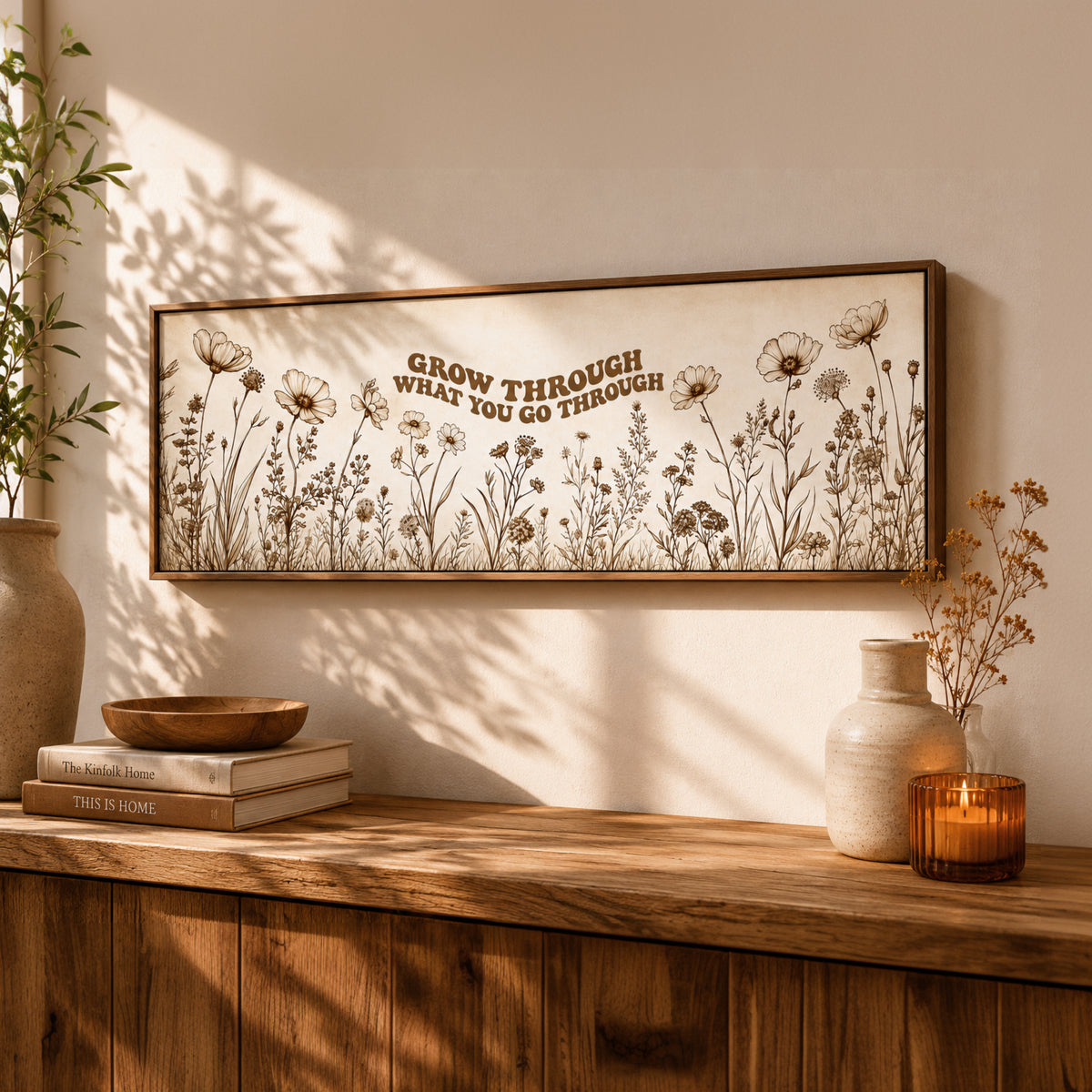 a wooden shelf with a framed picture of flowers, a stack of books, a candle, and a vase.