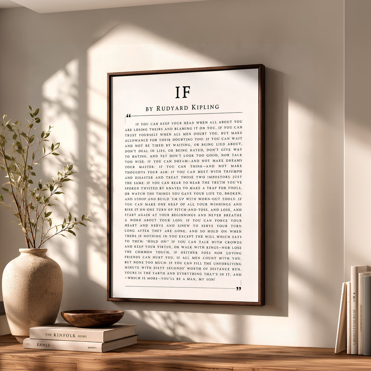 a vase with a plant on a table next to a framed book