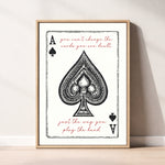 The image is a framed print featuring a spade playing card with the text "You can't change the cards you are dealt" and "Just the way you play the hand" written on it.