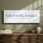 a wooden dresser with a white sign that reads "THE PATEL FAMILY EST. 2026" hanging on the wall above it.