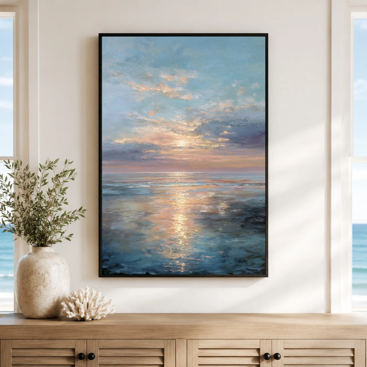 a large framed painting of a serene ocean scene with a sunset over the water, hanging on a wall above a wooden cabinet.
