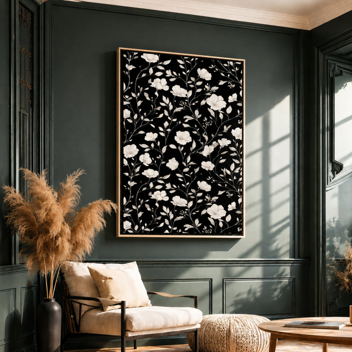 a living room with a large black and white floral print hanging on the wall above a white armchair. The room has dark green walls and a wooden floor, creating a cozy and inviting atmosphere.