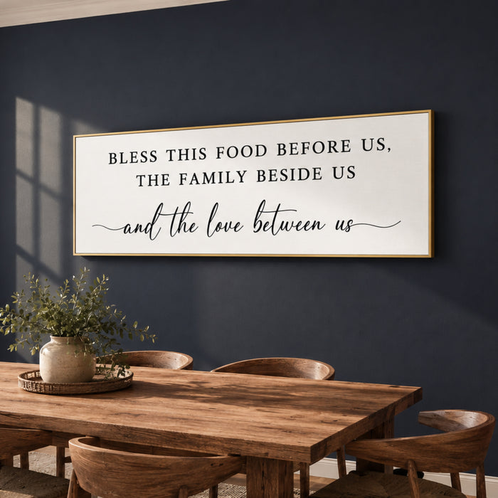 a wooden dining table with chairs, a potted plant, and a framed sign on the wall above the table.