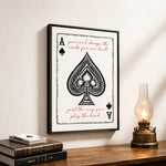 a framed poster with a spade playing card design, accompanied by a quote about playing the hand.