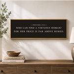 a framed quote on a wall above a wooden dresser, with a stack of books and a plant on the dresser.