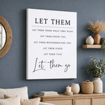 a wall with a white canvas that displays a motivational quote in black text, which reads "Let them think what they want, let them doubt you, let them misunderstand you, let them judge you, let them talk." The wall is decorated with various items such as a mirror, a shelf with vases, and some plants, creating a cozy and inviting atmosphere.