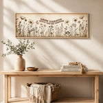 a wooden console table with a vase of greenery, a stack of books, and a woven basket. Above the table, there is a framed quote that reads "Grow through what you go through".