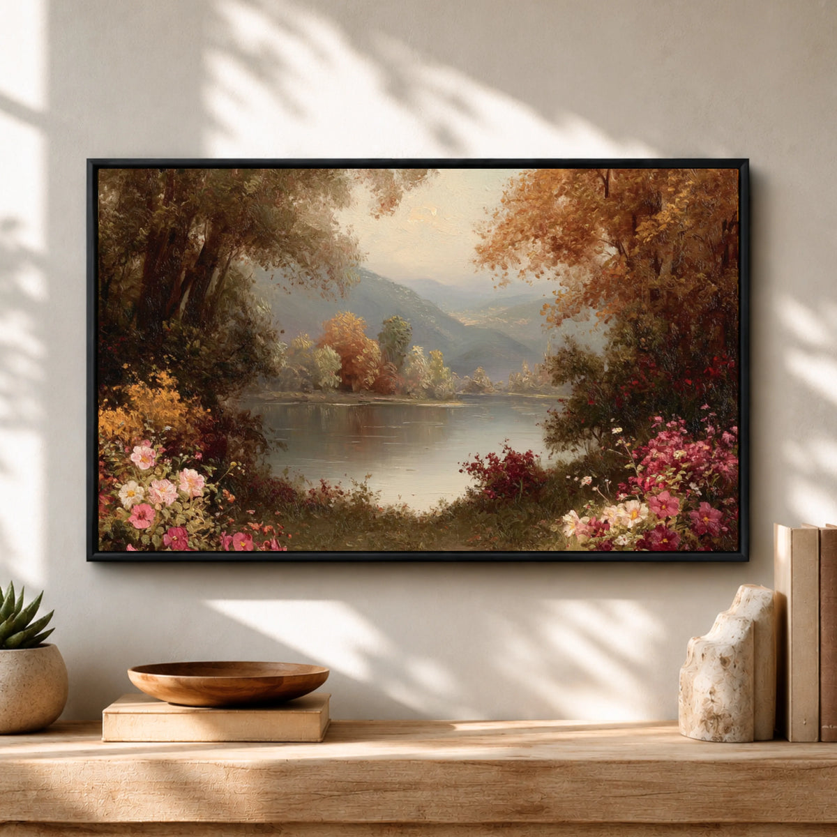 a framed painting of a serene landscape with a lake, trees, and colorful flowers, hanging on a wall above a wooden shelf with decorative items.