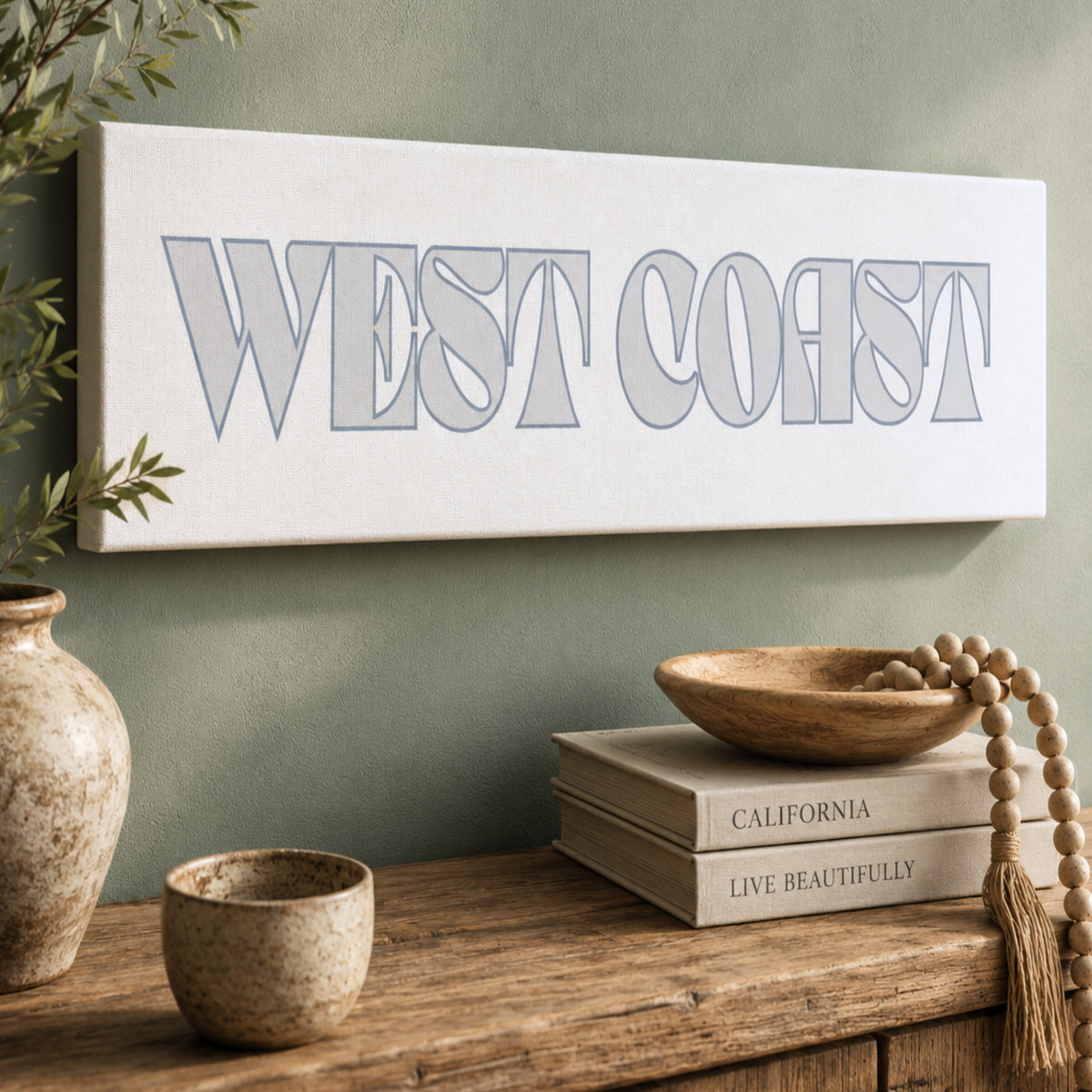 a wooden shelf with various decorative items, including a vase, a bowl, and a stack of books. Above the shelf, there is a sign that says "West Coast" in a stylized font.