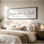 A bedroom with a large bed, white bedding, and a framed inspirational quote on the wall above it.